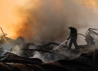 A firefighter is putting out a fire following an explosion at a warehouse in Zhytomyr