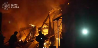 Rescue workers are putting out a fire at a garage following a Russian drone strike in Kyiv