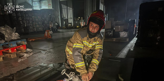 A rescue worker is dealing with the aftermath of a drone attack in the Kyiv region
