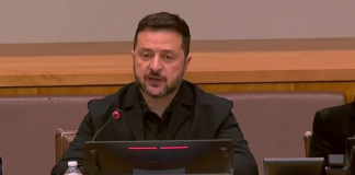 Volodymyr Zelenskyy is speaking at a table with a microphone.