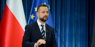 Владислав Косіняк-Камиш виступає на тлі прапорів Польщі та ЄС