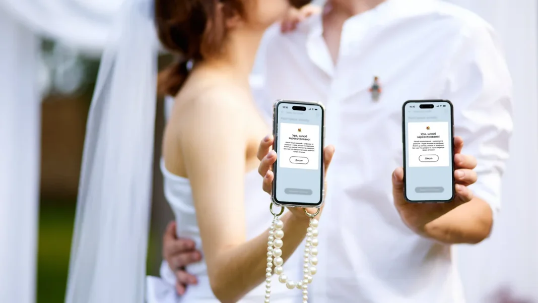 Online weddings A smartphone with the Diia app and wedding rings