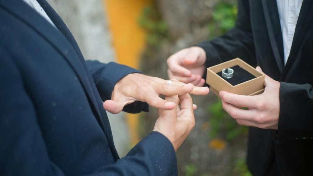 Одностатева пара обмінюється обручками під час церемонії