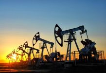 Oil pumping units at the field against the backdrop of the setting sun.