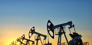 Oil pumping units at the field against the backdrop of the setting sun.