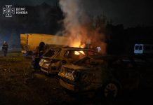 Russia struck Kyiv whilst Zelenskyy was speaking to members of Congress Rescue workers stand beside burning and damaged cars following the night-time attack on Kyiv.