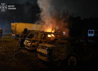РФ ударила по Києву під час розмови Зеленського з конгресменами Рятувальники біля палаючих і пошкоджених автомобілів після нічної атаки на Київ.