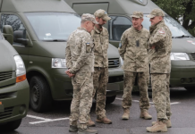 Rules of the Traffic Control Centre and the police: who checks documents and is authorised to detain people Four soldiers in camouflage are talking next to green service minibuses