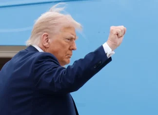 Трамп заявив, що війна Росії проти України наближається до завершення Дональд Трамп у темному костюмі піднімає стиснутий кулак на тлі блакитного літака