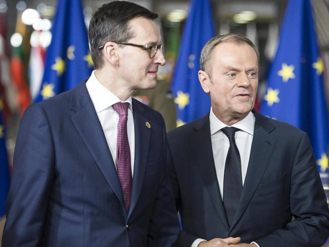 Матеуш Моравецький і Дональд Туск на тлі прапорів Європейського Союзу.