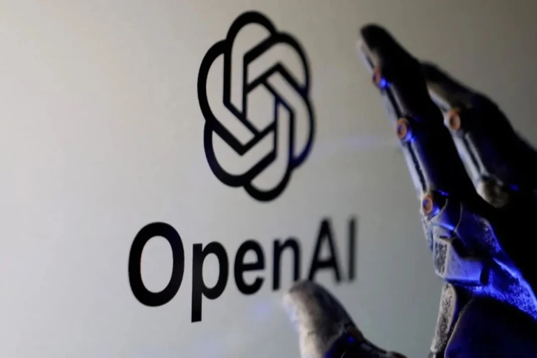 20_big-v1777285944 Логотип OpenAI на екрані поруч із роботизованою рукою, що символізує розвиток штучного інтелекту.