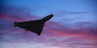 The silhouette of a drone in flight against the backdrop of the evening sky