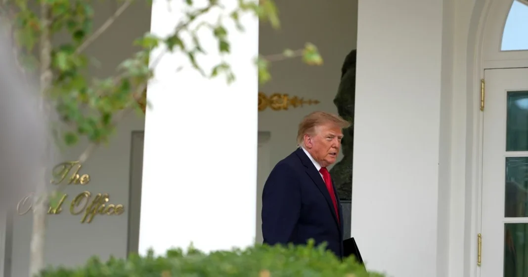 30caf4c975599d01b3960e7bf14ca712 US President Donald Trump, wearing a dark blue suit and a red tie, at the entrance to the White House.