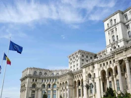 У Румунії після шести місяців кризи затвердили новий уряд Будівля Палацу парламенту Румунії в Бухаресті з прапорами Румунії та Європейського Союзу перед головним фасадом.