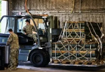 Ukraine will be able to procure weapons through the NATO agency NSPA Soldiers standing next to a forklift truck and pallets of ammunition in a hangar