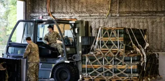 Військові біля навантажувача та піддонів із боєприпасами в ангарі