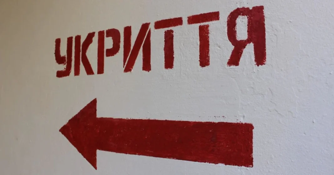 Червоний напис «УКРИТТЯ» зі стрілкою на білій стіні