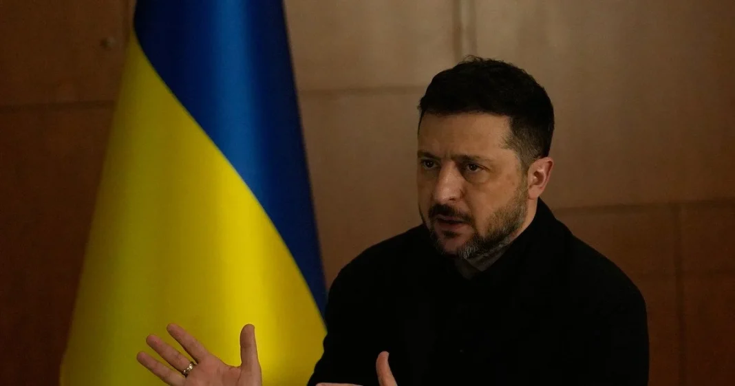 9151eb5ea911943f018cf24507dfd0f2 The President of Ukraine, Volodymyr Zelenskyy, dressed in black, delivering a speech against the backdrop of the Ukrainian national flag.