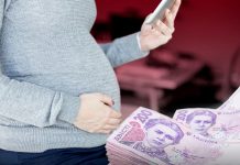 7 000 та 10 500 грн на дитину: як оформити виплати через «Дію» Вагітна жінка зі смартфоном у руках на тлі українських банкнот номіналом 200 гривень — оформлення державної допомоги через «Дію».