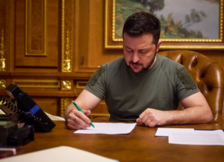 Зеленський підписав закони про ПДВ на онлайн-посилки та доходи платформ Володимир Зеленський підписує документ за робочим столом