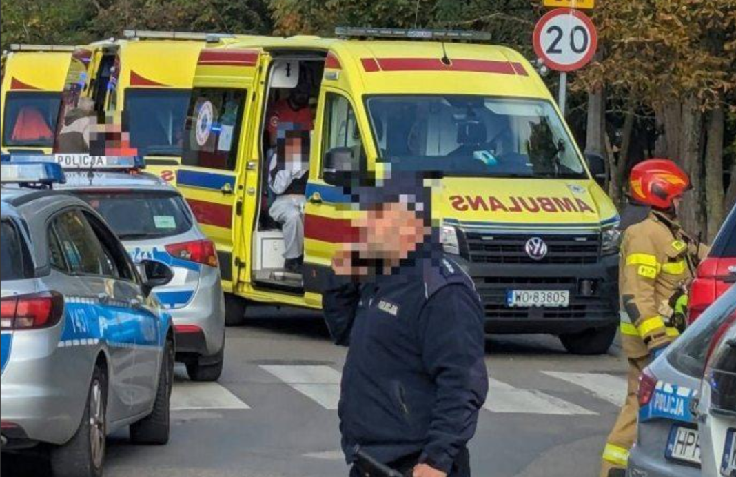 «Кривава п’ятниця» в Польщі Поліцейські автомобілі, карети швидкої допомоги та рятувальник на місці надзвичайної події в Польщі