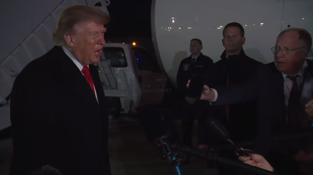 Donald Trump answers questions from journalists outside the presidential aircraft upon his return from a trip to Tennessee.