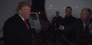Donald Trump answers questions from journalists outside the presidential aircraft upon his return from a trip to Tennessee.