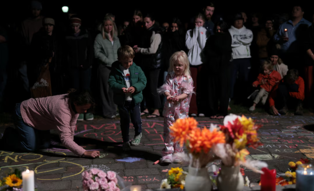 People at the makeshift memorial People with children at a makeshift memorial holding candles