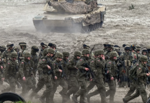 Польські військові на полігоні на тлі бронетехніки