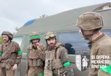 320 днів на «нулі»: неймовірне повернення бійців 65-ї бригади Четверо військових у спорядженні стоять біля евакуаційного мікроавтобуса