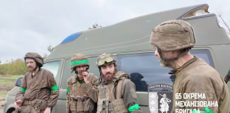 320 днів на «нулі»: неймовірне повернення бійців 65-ї бригади Четверо військових у спорядженні стоять біля евакуаційного мікроавтобуса