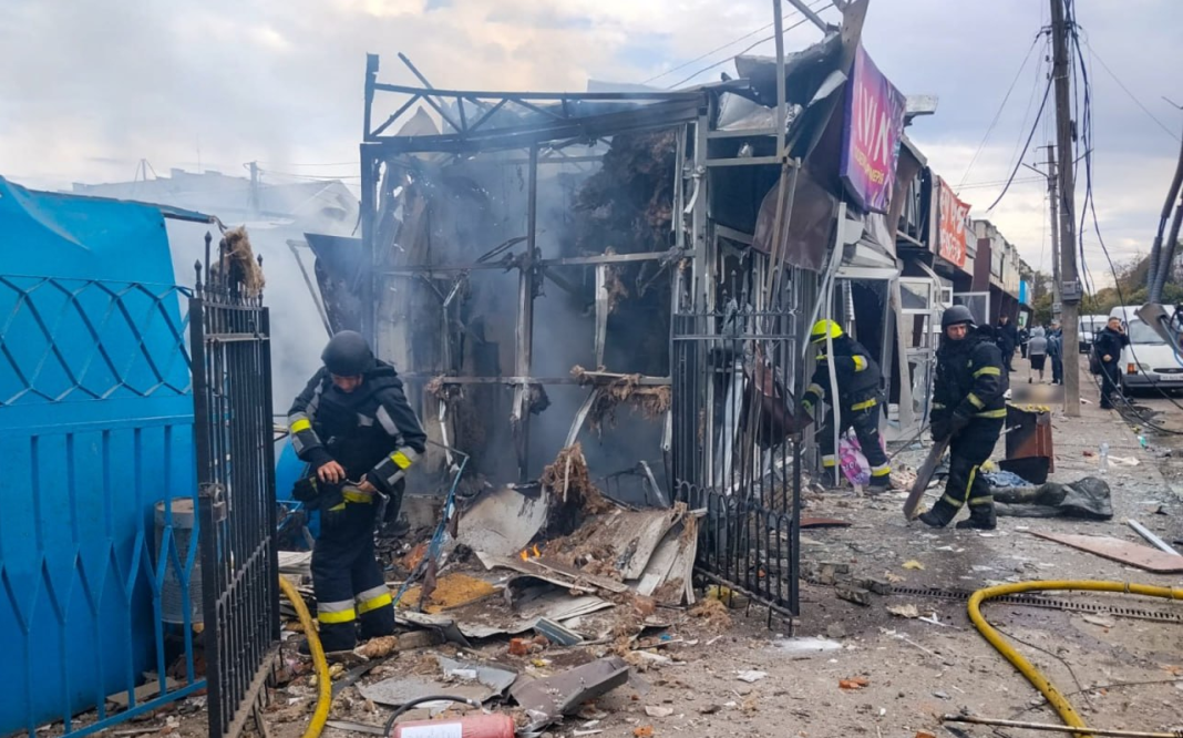 Rescue workers from the State Emergency Service are working amongst the ruined and burnt-out market stalls following a Russian missile strike on the market in Lozova.