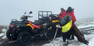 Mountain rescuers from Zakarpattia are using a quad bike to assist female tourists in snowy and foggy conditions in the Carpathians near Pylypets
