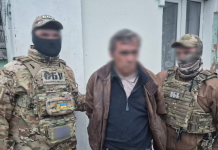 СБУ затримала агента ФСБ, який готував удари по київських ТЕЦ Співробітники контррозвідки СБУ в тактичному спорядженні стоять поруч із затриманим чоловіком