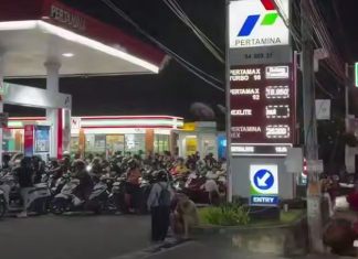 A fuel crisis has broken out in Bali: queues and traffic jams stretch for kilometres A queue of motorbikes and people outside the Pertamina petrol station at night