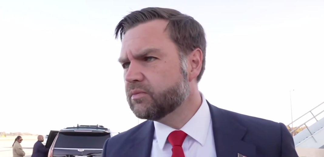 Віцепрезидент США Джей Ді Венс у темному костюмі та червоній краватці відповідає на запитання журналістів біля літака.