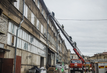 Рятувальники ДСНС на пожежній автодрабині біля багатоповерхової будівлі у Харкові.