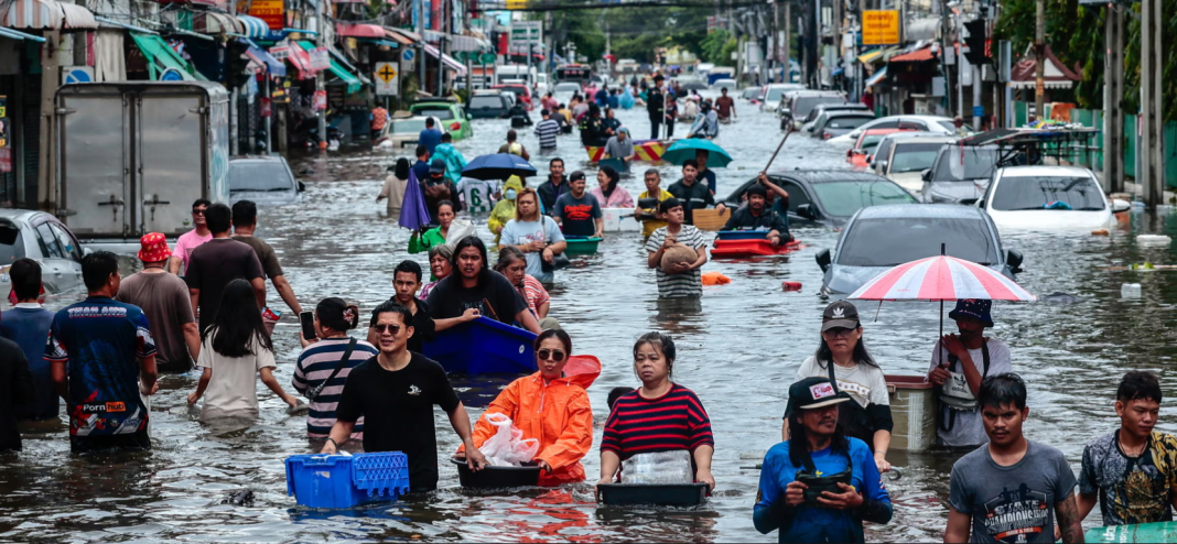 People are walking along a flooded street in Bangkok