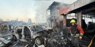 Рятувальник серед згорілих автомобілів після удару по Києву