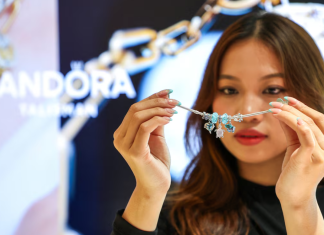 Pandora відкрила найбільший завод у В’єтнамі за $150 млн Жінка тримає перед собою сріблястий браслет Pandora із підвісками