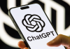 Логотип ChatGPT на екрані смартфона на тлі символіки OpenAI