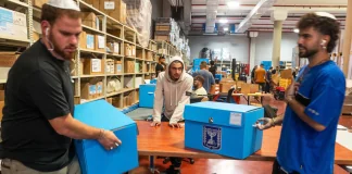 Працівники виборчої комісії в Ізраїлі обробляють сині скриньки з виборчими матеріалами