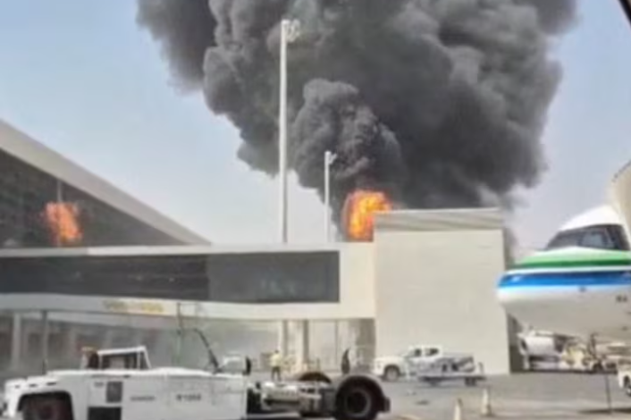 Flames above the airport Smoke and flames rising from the airport buildings next to the aeroplane