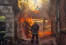На Сумщині після російських атак горіли цивільні об’єкти Двоє рятувальників ДСНС гасять сильну пожежу в пошкодженій будівлі, охопленій вогнем і густим димом.