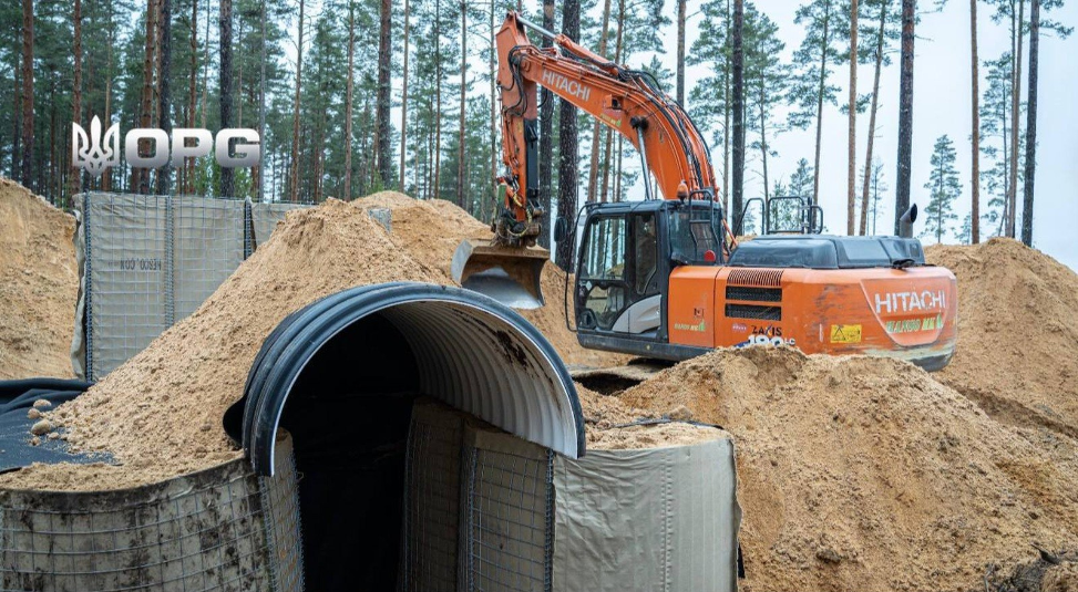 Бункер в Естонії Екскаватор Hitachi проводить земляні роботи біля входу до оборонного бункера в лісистій місцевості Естонії під час облаштування Балтійського оборонного поясу