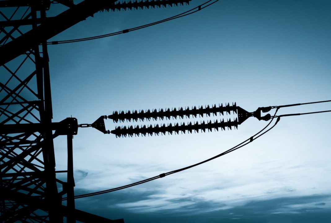 The silhouette of a pylon on a high-voltage power line