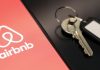 Airbnb заборонить господарям вимагати прибирання: що зміниться з 20 листопада Логотип сервісу оренди житла Airbnb на екрані смартфона поруч із ключами від помешкання