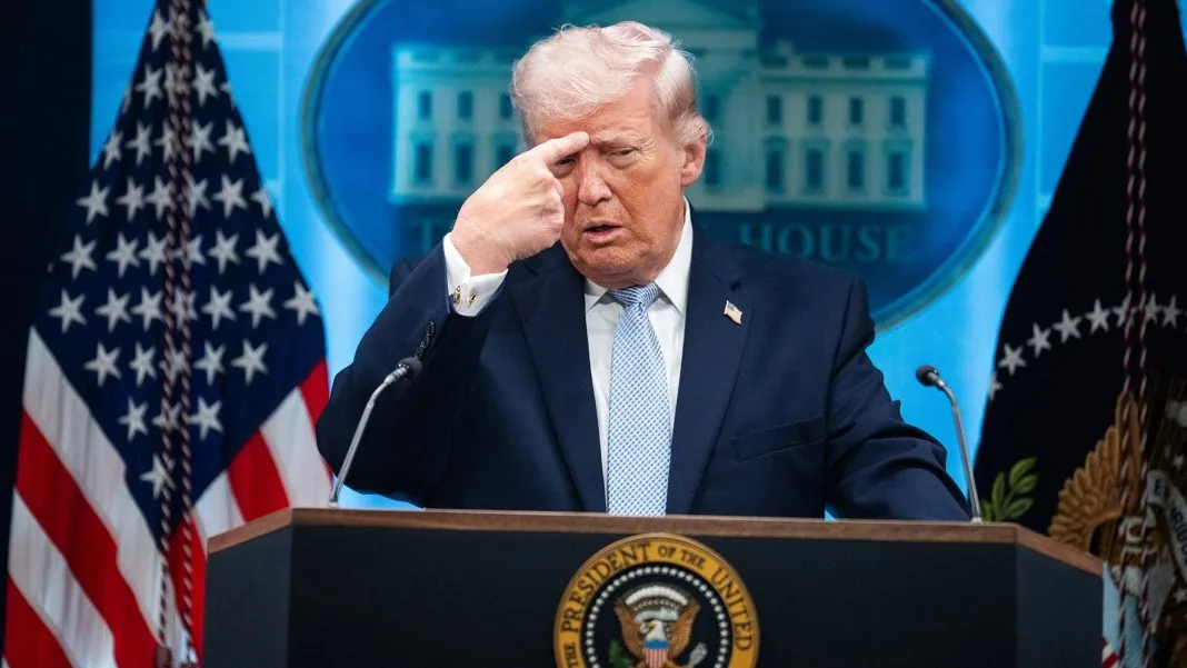 Дональд Трамп виступає за трибуною на тлі прапорів США
