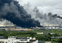 Smoke is rising above the oil refinery complex, where a large-scale fire can be seen on the premises.