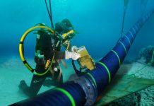 Водолаз працює з великим підводним телекомунікаційним кабелем на морському дні
